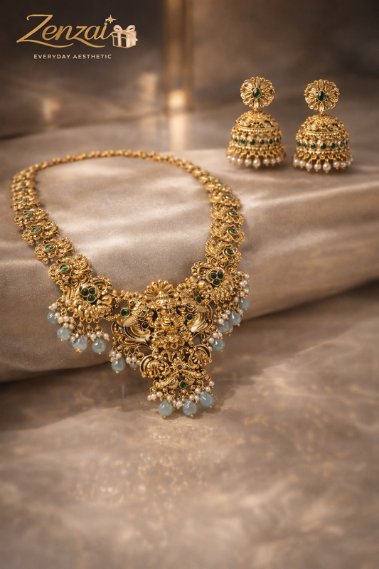 Zenzai ethnic temple necklace with floral motifs, green gem accents and pearl drop jhumkas in gold finish